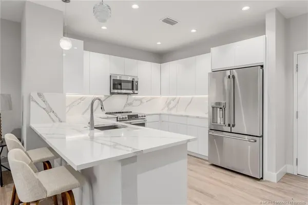 a kitchen with kitchen island a sink appliances and cabinets