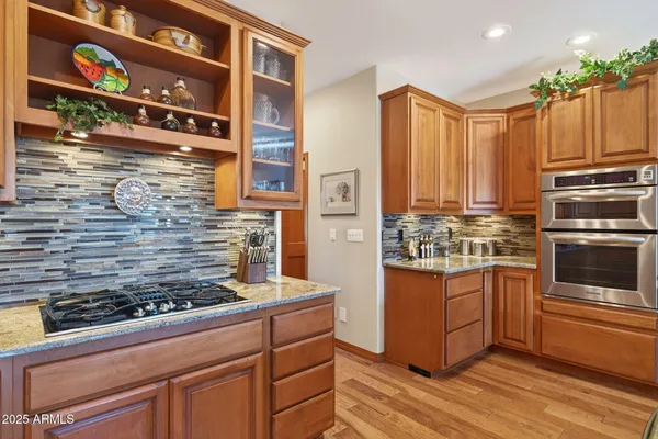 a kitchen with stainless steel appliances granite countertop a stove a sink and a microwave