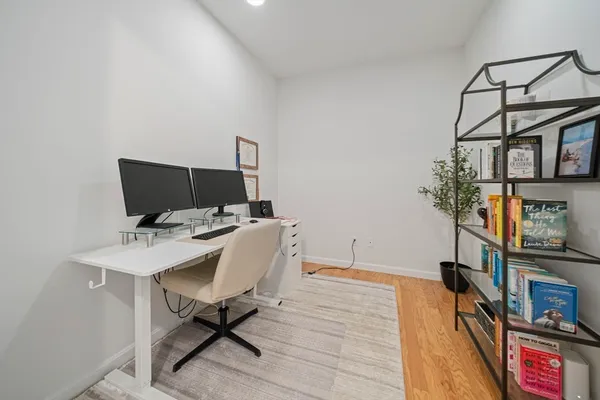 a view of a workspace with furniture and wooden floor