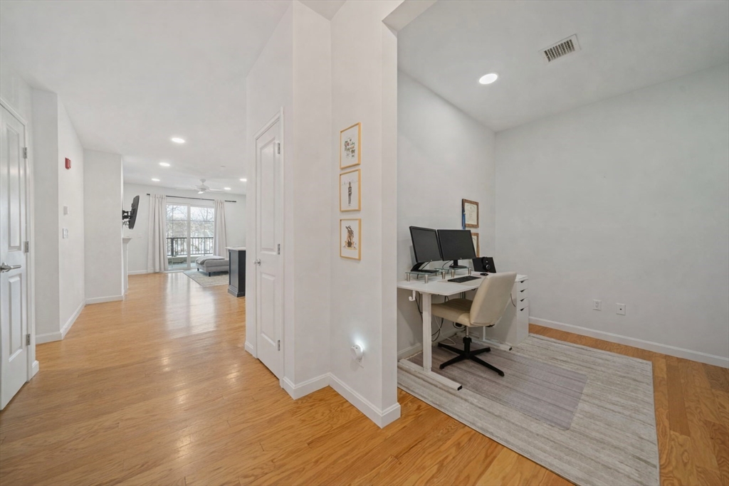 200 Revere Street, Unit 4104 Canton, MA 02021 - Photo 14 of 28 a view of a hallway with wooden floor windows and a livingroom