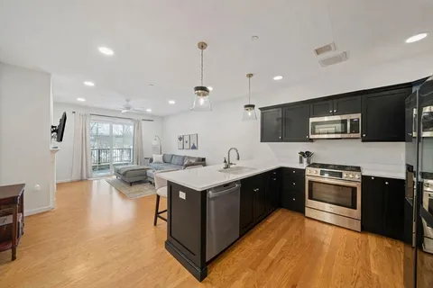 a large kitchen with stainless steel appliances granite countertop a stove and a sink