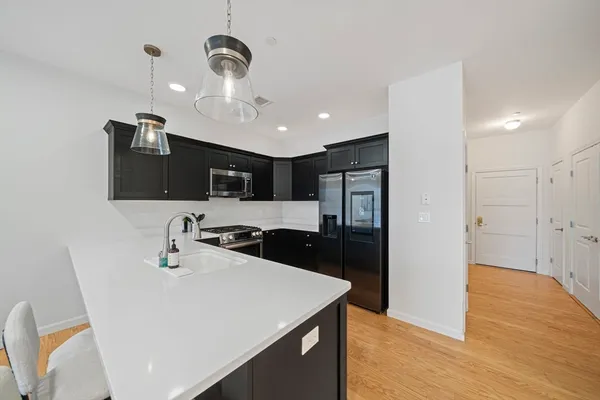 a kitchen with stainless steel appliances granite countertop a sink a refrigerator and a stove