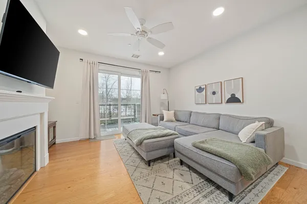 a living room with furniture a flat screen tv and a fireplace