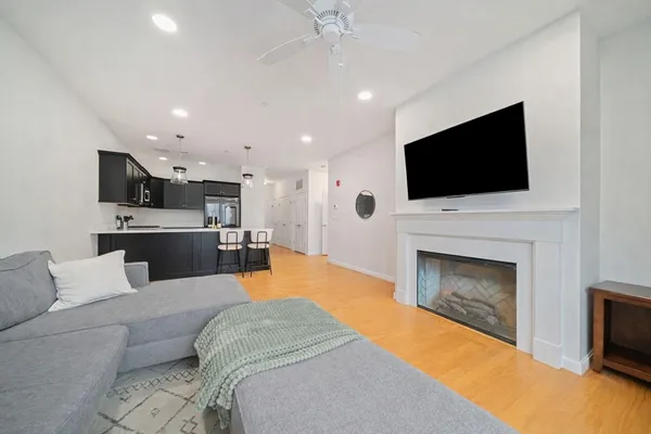 a living room with furniture a fireplace and a flat screen tv