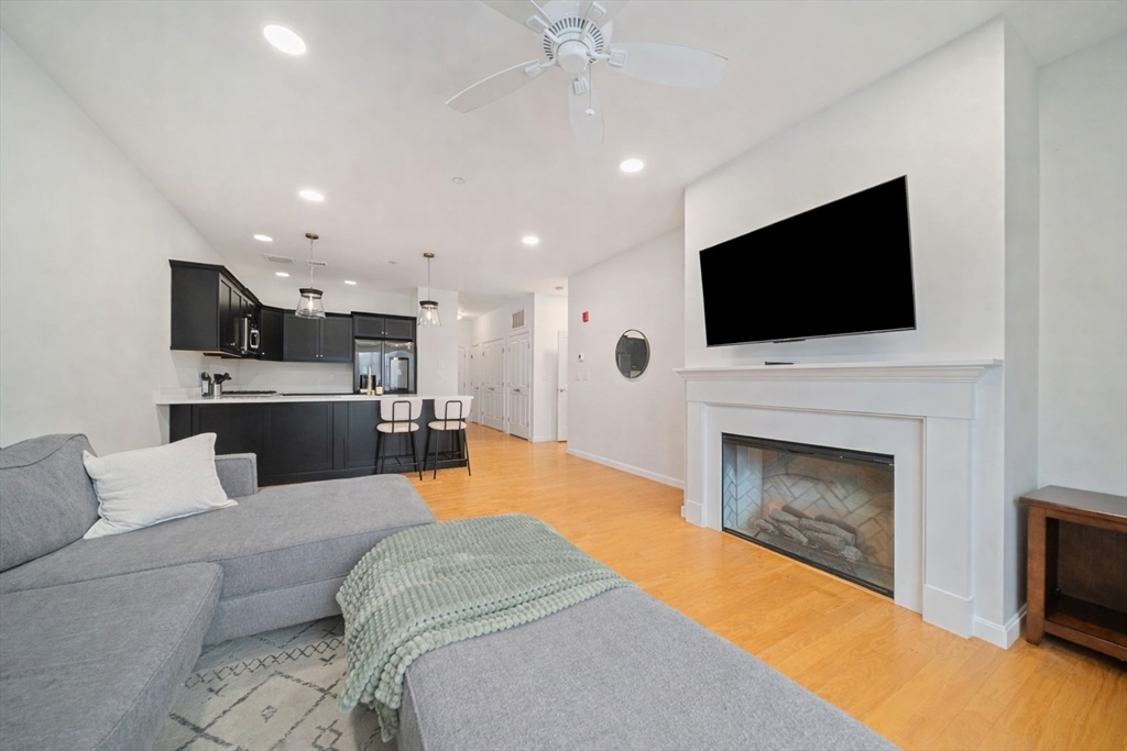 200 Revere Street, Unit 4104 Canton, MA 02021 - Photo 9 of 28 a living room with furniture a fireplace and a flat screen tv