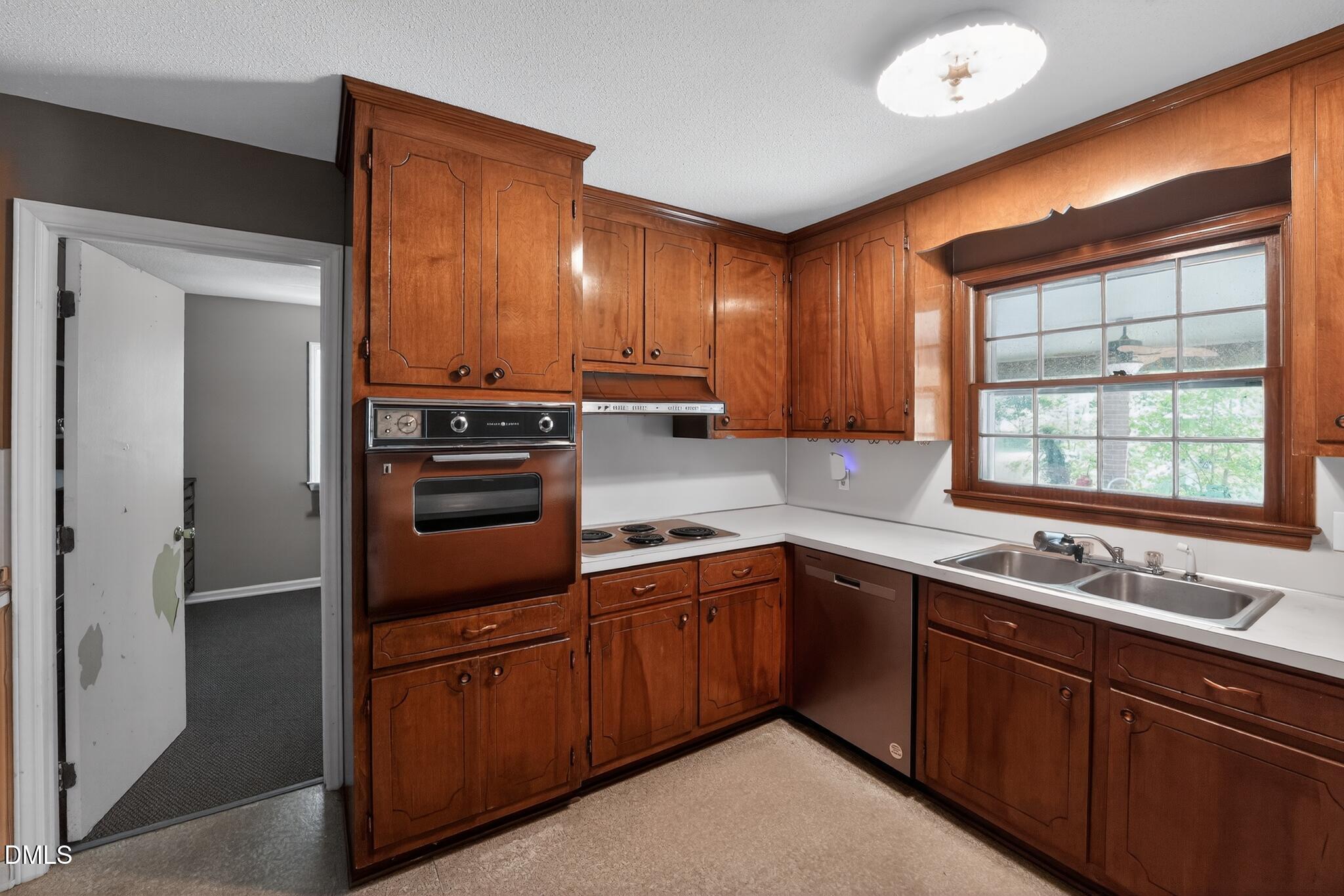 1034 Jerome Road Durham, NC 27713 - Photo 16 of 35 a kitchen with stainless steel appliances granite countertop wooden cabinets a sink and a window
