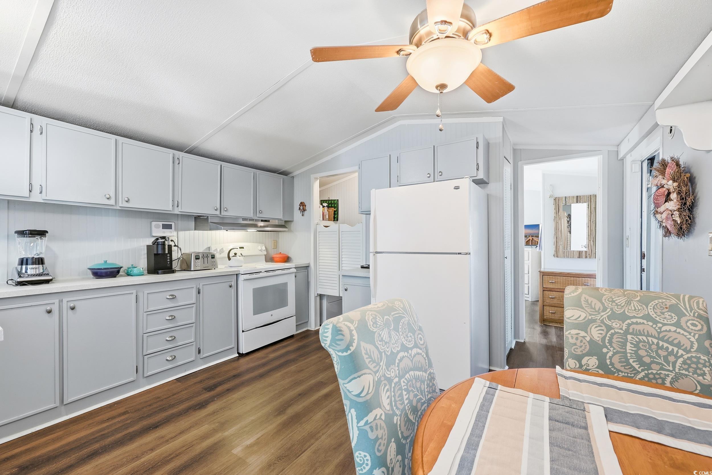 1017 Foxfire Drive North Myrtle Beach, SC 29582 - Photo 11 of 36 Kitchen featuring white appliances, light countertops, dark wood finished floors, lofted ceiling, and a ceiling fan