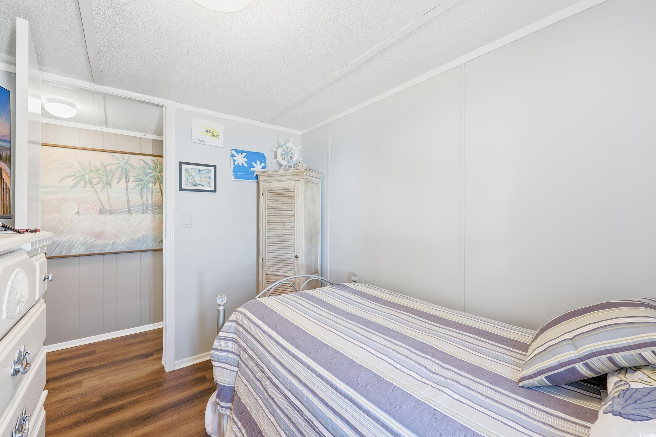 1017 Foxfire Drive North Myrtle Beach, SC 29582 - Photo 20 of 36 Bedroom featuring a decorative wall, dark wood-style floors, and wooden walls
