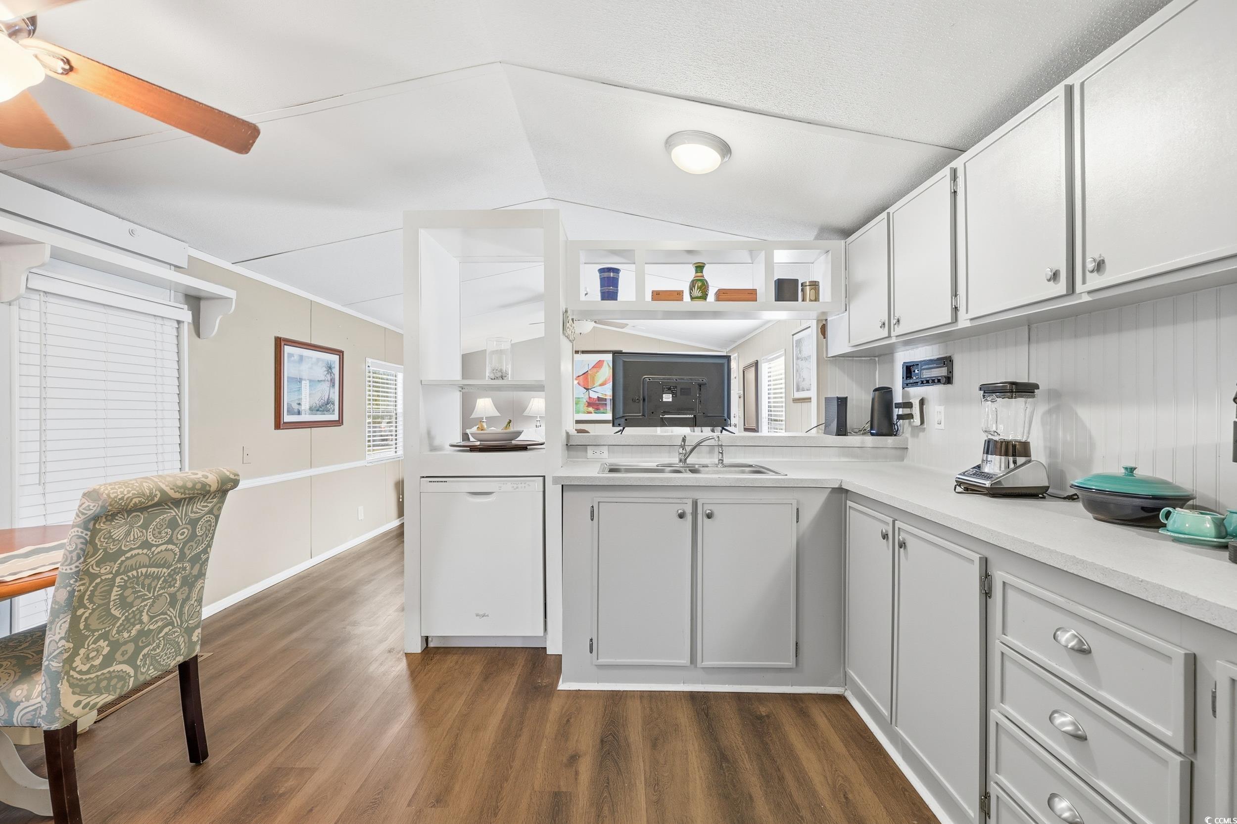 1017 Foxfire Drive North Myrtle Beach, SC 29582 - Photo 8 of 36 Kitchen featuring light countertops, white cabinets, white dishwasher, dark wood-type flooring, and lofted ceiling