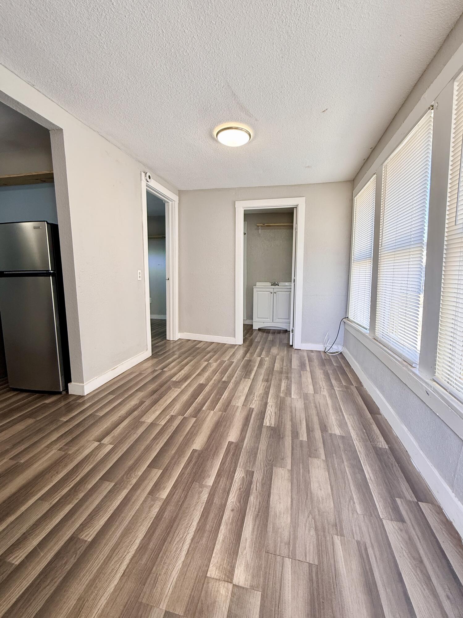 2109 22nd Street, Unit REAR Lubbock, TX 79411 - Photo 2 of 11 a view of empty room with wooden floor and fan