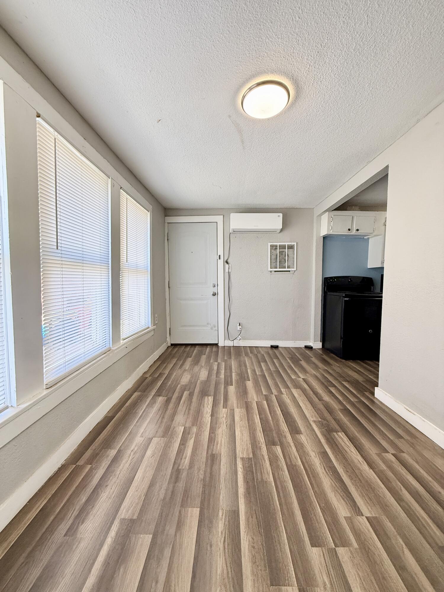 2109 22nd Street, Unit REAR Lubbock, TX 79411 - Photo 3 of 11 a view of empty room with wooden floor and fireplace