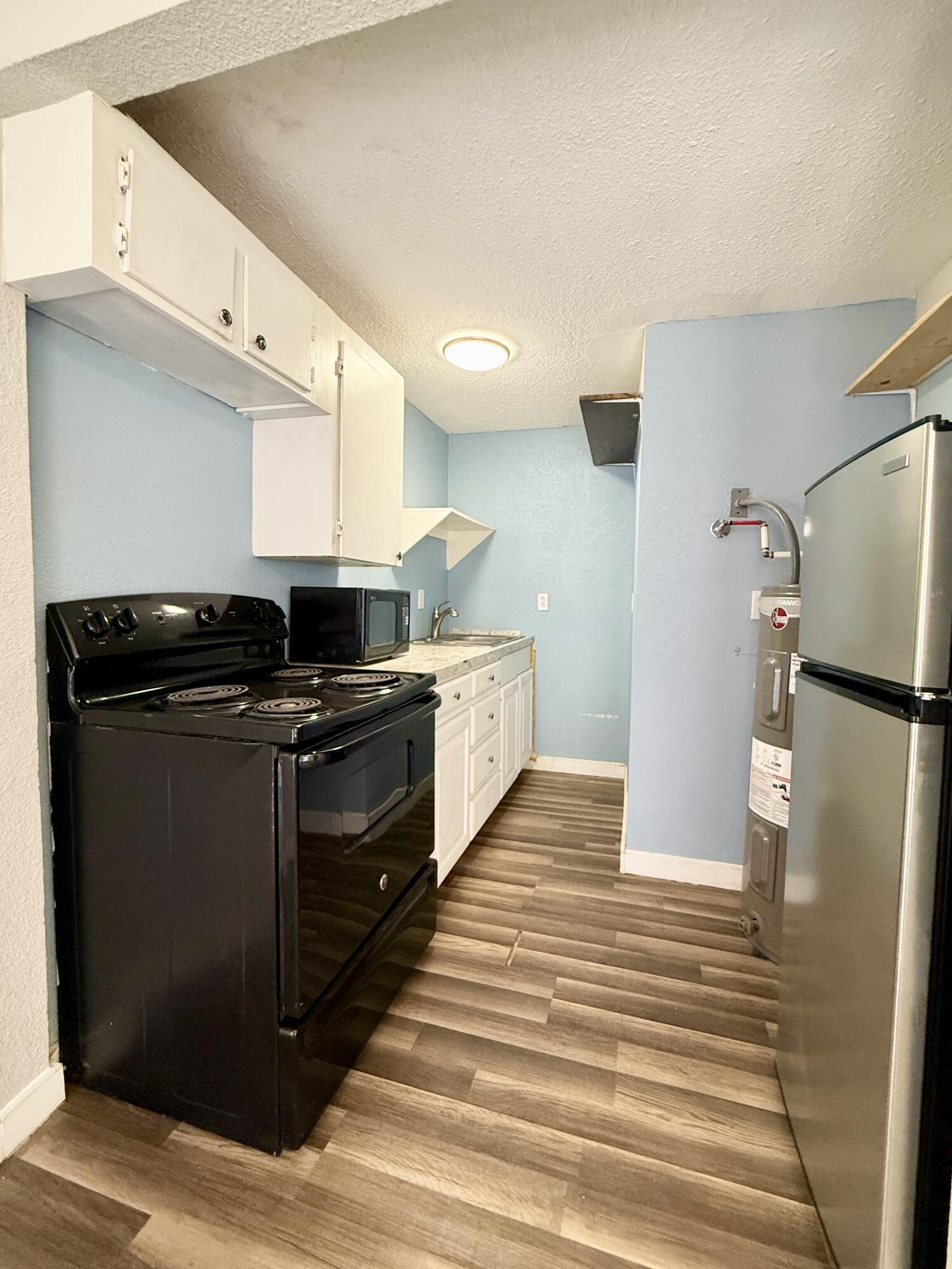 2109 22nd Street, Unit REAR Lubbock, TX 79411 - Photo 7 of 11 a kitchen with stainless steel appliances a refrigerator and a stove