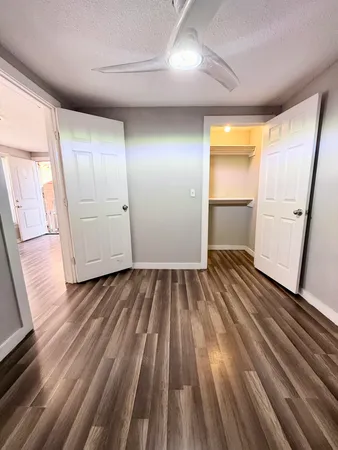 a view of a room with wooden floor and electronic appliances