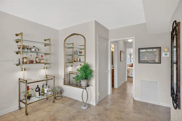 a living room with stainless steel appliances granite countertop a sink and cabinets with wooden floor