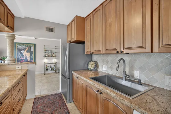 a kitchen with stainless steel appliances granite countertop a sink a stove and cabinets