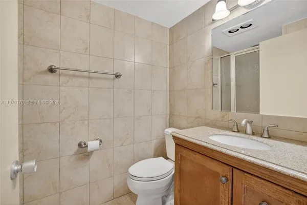 a view of a hallway with a livingroom and a bathroom with sink