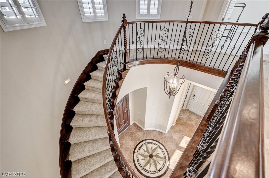 2793 Rosenhearty Drive Henderson, NV 89044 - Photo 31 of 85 A grand winding staircase with ornate ironwork banister welcomes guests into this elegant foyer.