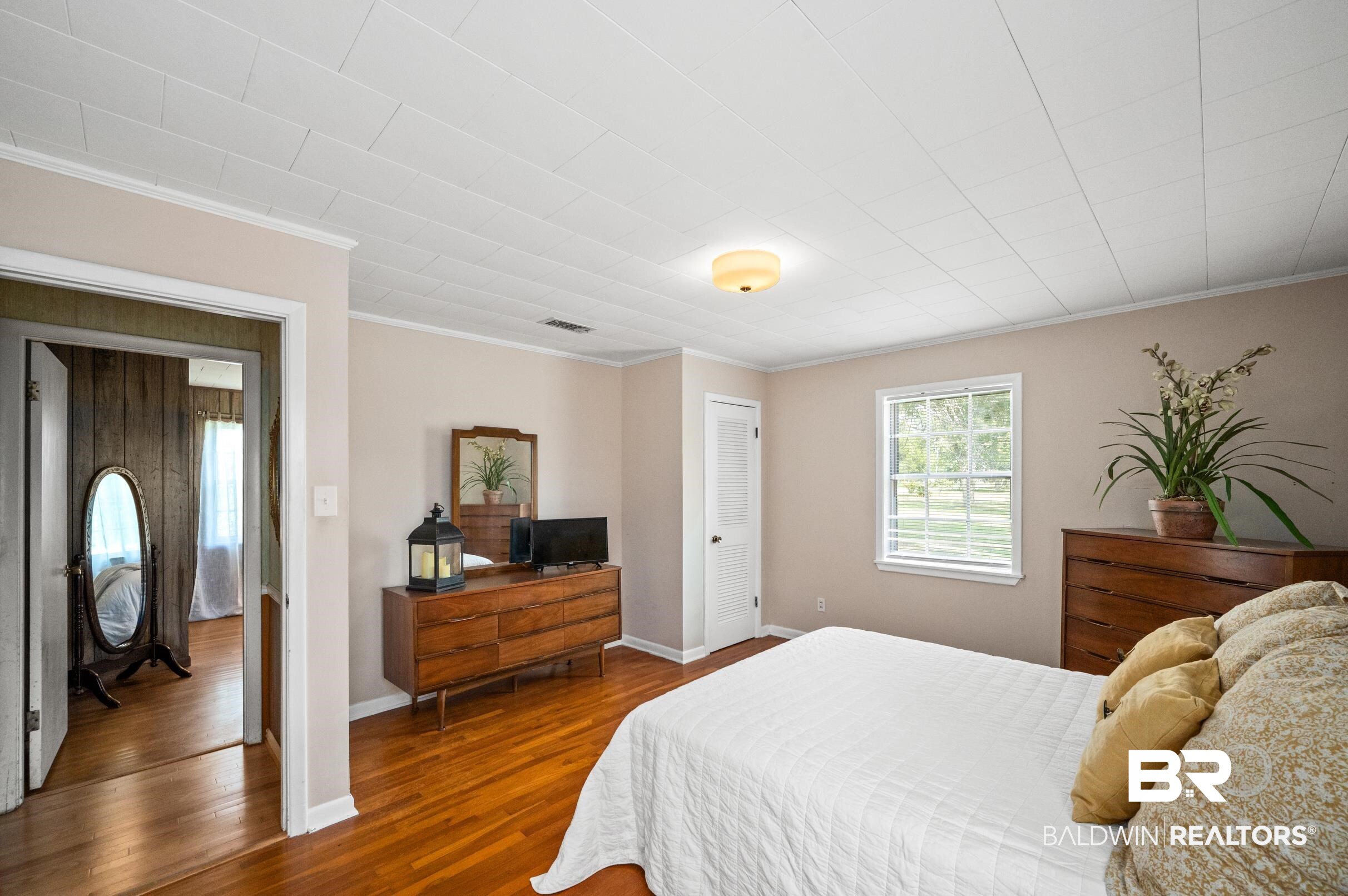 15600 Fackler Road Loxley, AL 36551 - Photo 13 of 51 Bedroom featuring a closet, ornamental molding, and wood-type flooring