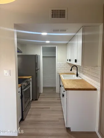 a kitchen with stainless steel appliances granite countertop a sink and a stove top oven