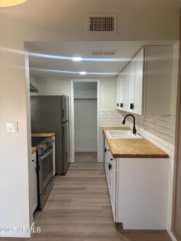 a kitchen with stainless steel appliances granite countertop a sink and a stove top oven