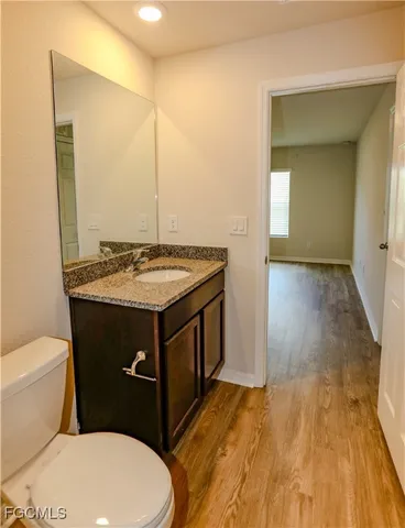 a bathroom with a granite countertop toilet sink and mirror