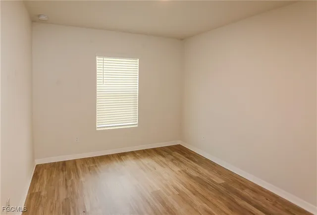 a view of a room that has wooden floor and a window