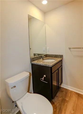 a bathroom with a granite countertop toilet and a sink