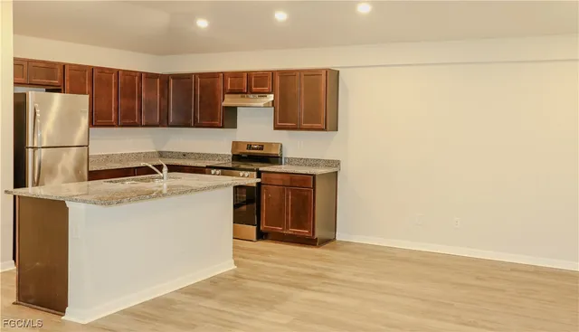 a kitchen with a sink a stove and a refrigerator