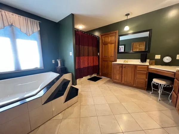 a spacious bathroom with a mirror and a bathtub