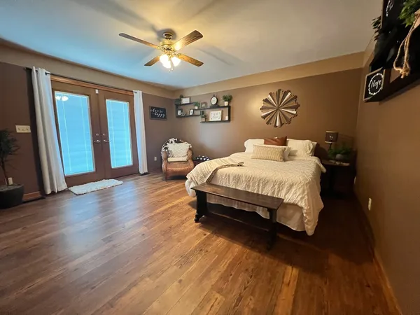 a bedroom with a bed ceiling fan and a window