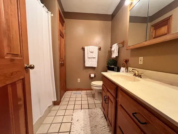 a spacious bathroom with a sink a toilet a mirror and shower