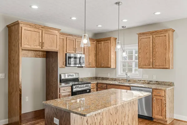 a kitchen with stainless steel appliances granite countertop a sink refrigerator and microwave