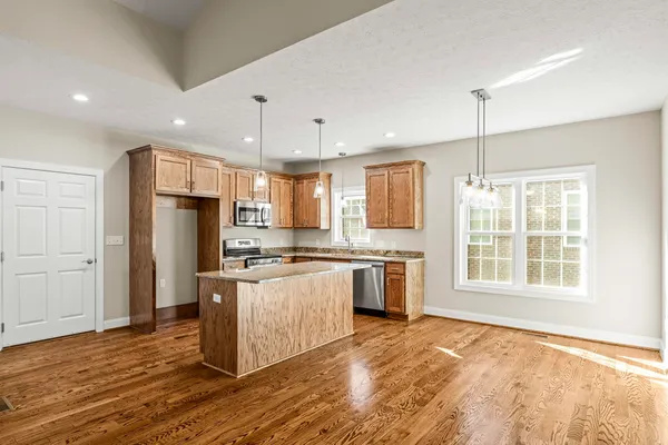 a large kitchen with stainless steel appliances granite countertop a stove and a refrigerator