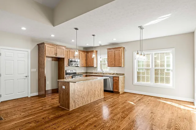 a kitchen with stainless steel appliances granite countertop a stove a sink and a microwave