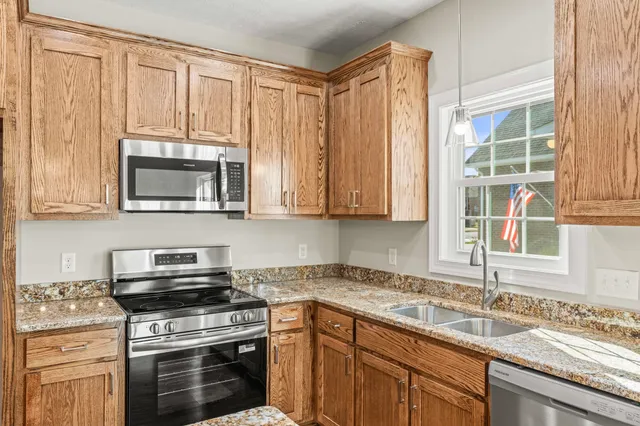 a kitchen with granite countertop a stove and a microwave