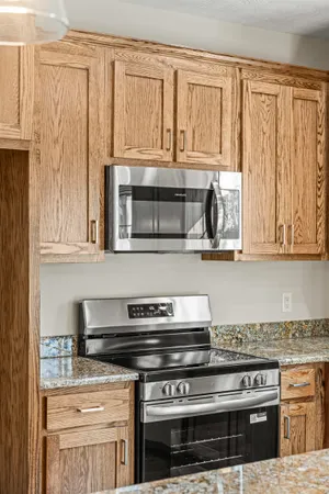 a kitchen with granite countertop a stove and a microwave