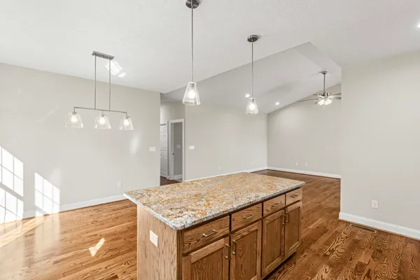 a kitchen with kitchen island a chandelier and wooden floor