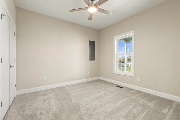an empty room with a window and a fan
