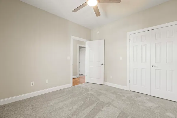 an empty room with a ceiling fan and a window