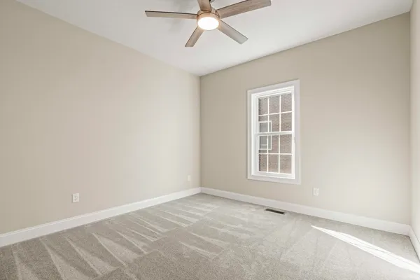 an empty room with a window and a fan