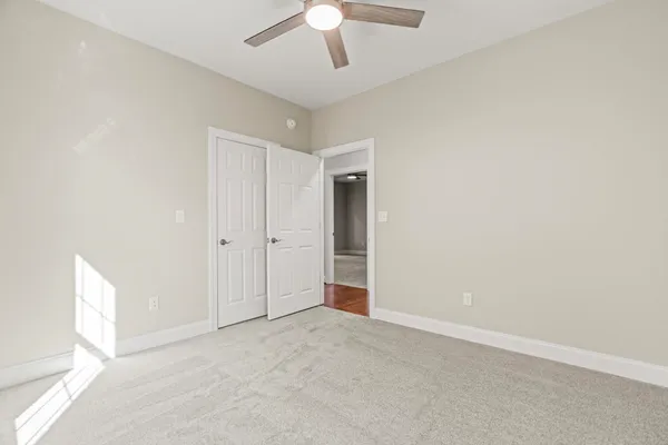 an empty room with chandelier fan