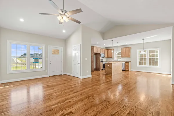 a view of an empty room with window and wooden floor