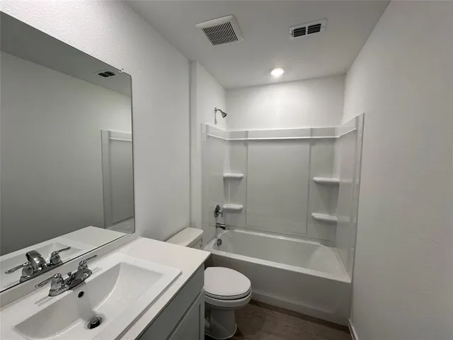 a bathroom with a sink toilet vanity and shower