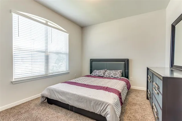 a bed sitting in a bedroom next to a window