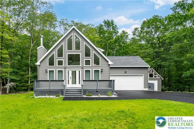 a view of a house with a yard and sitting area