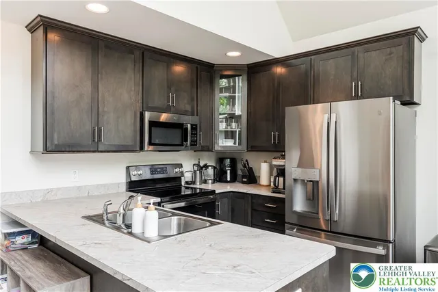 a kitchen with granite countertop a refrigerator and a sink