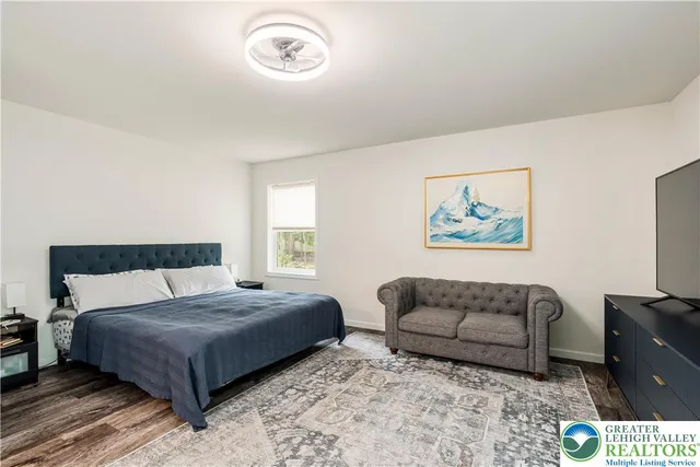 a bedroom with bed couch and window