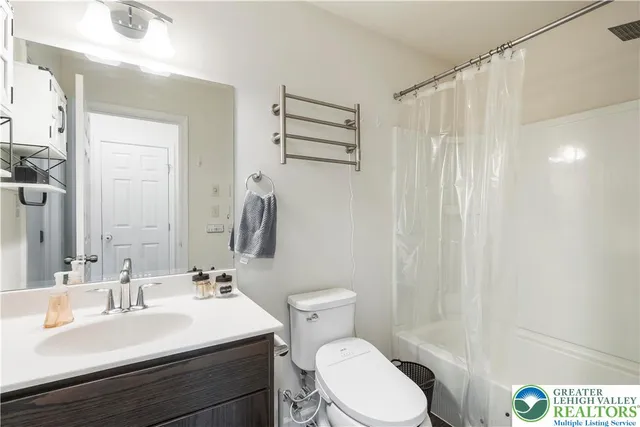 a bathroom with a sink a toilet and shower curtain