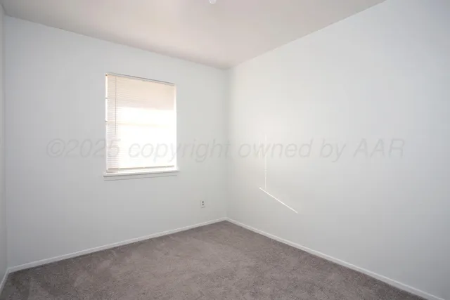 an empty room with a window and a ceiling fan