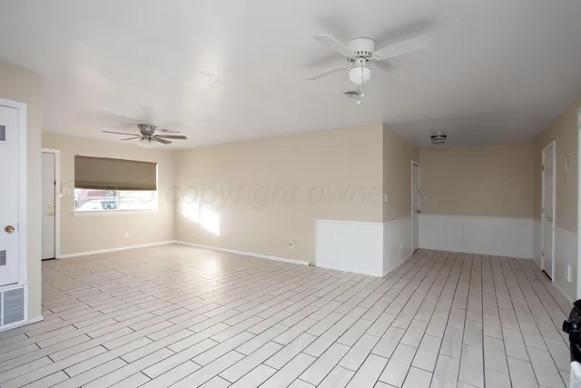 a view of a kitchen with refrigerator and window